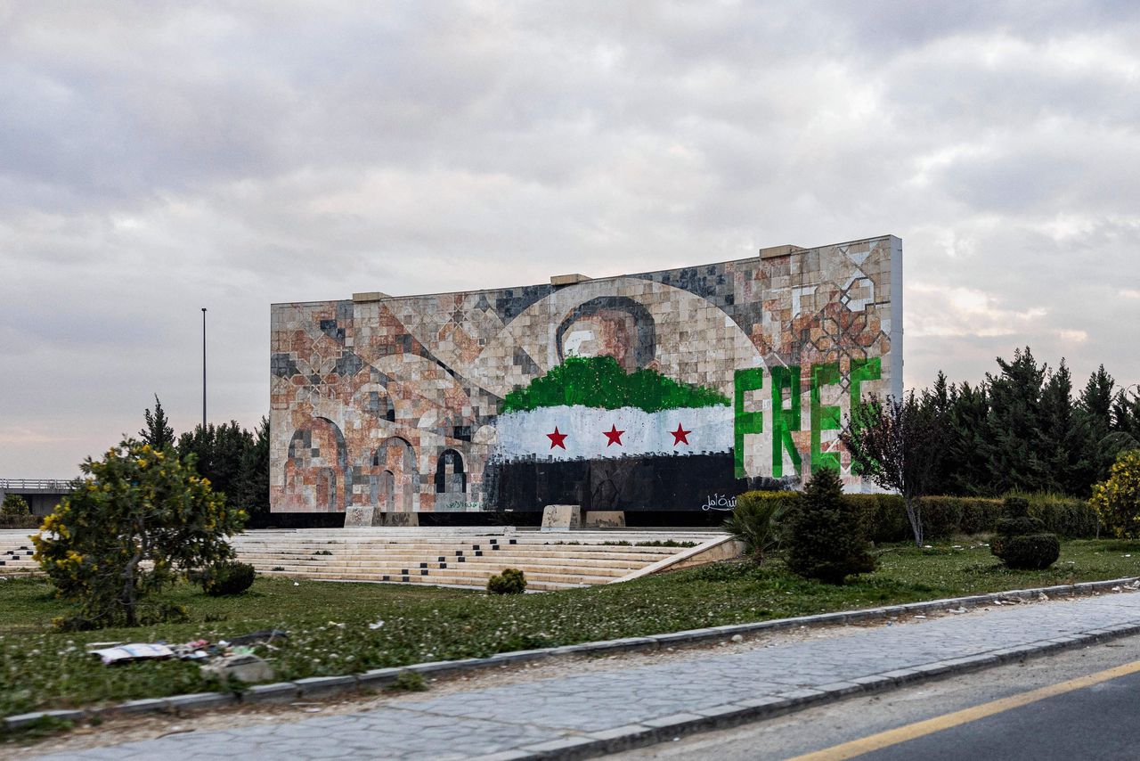 Een groot monument voor voormalig leider Hafez al-Assad naast een toegangsweg tot Damascus is overgeschilderd met de Syrische revolutionaire vlag. Een van de eerste besluiten van de nieuwe regering was het aanpassen van de oude rood-wit-zwarte vlag die werd gebruikt door het Assad-regime.